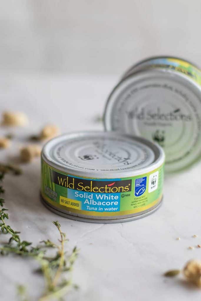  Wild Selections Tuna in a can shown with thyme sprigs and cashews.