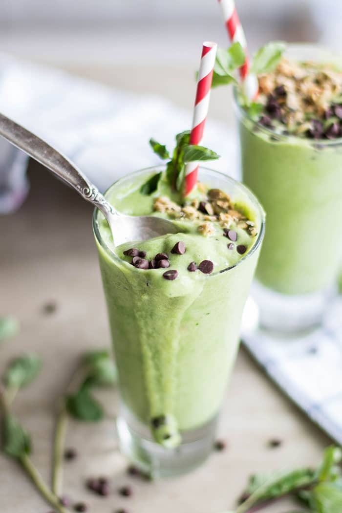 Chocolate chips sprinkled on top of healthy peppermint green smoothies.