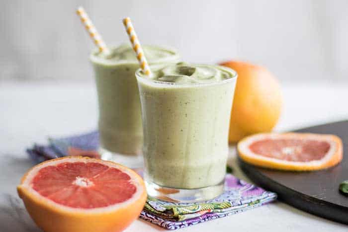 Two glasses of a green metabolism boosting smoothie, showing the thick and creamy texture.