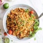 Whole30 rice recipe shown in a bowl with Mexican garnishes.