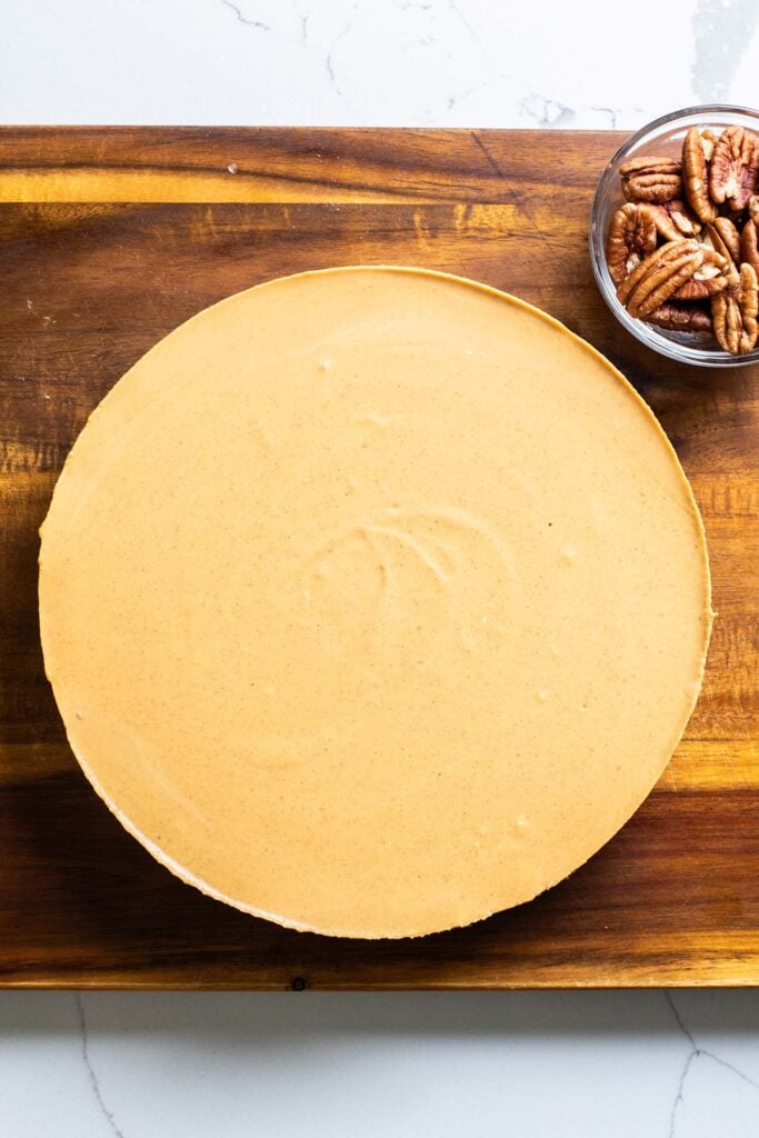 A pumpkin cheesecake removed from the springform pan, fully set.