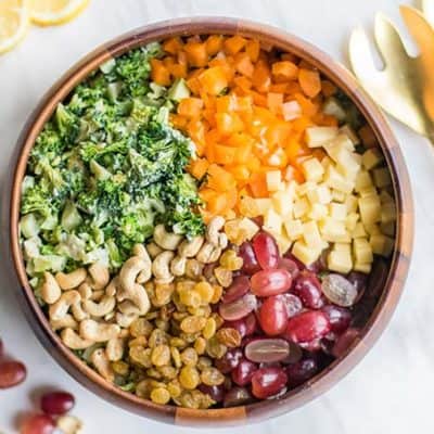 A healthy broccoli salad recipe with grapes, raisins, cashews, peppers, and cheese.