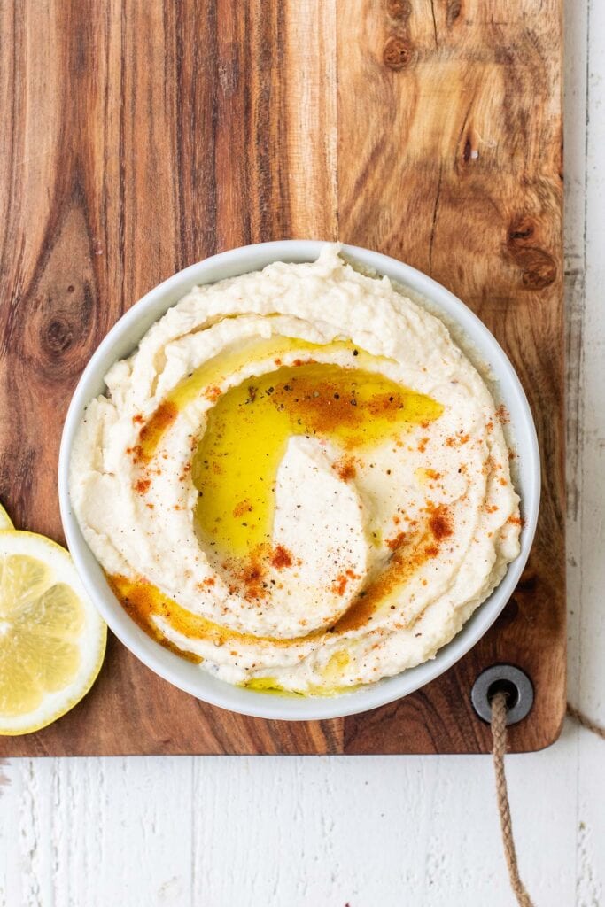 Hummus shown garnished with paprika and olive oil.