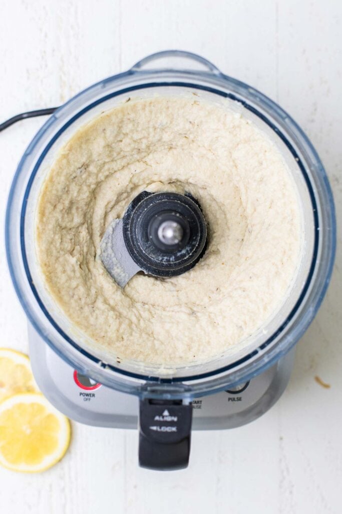 Smooth hummus shown in a food processor bowl.