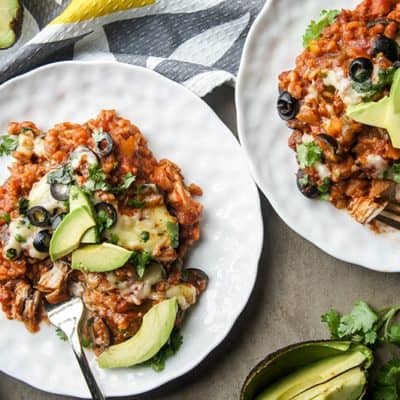 Two plates with large portions of crockpot chicken and brown rice.