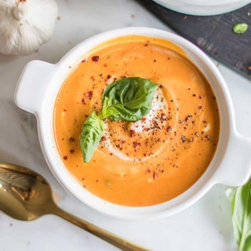 An artfully swirled bowl of tomato basil soup with cashew cream.