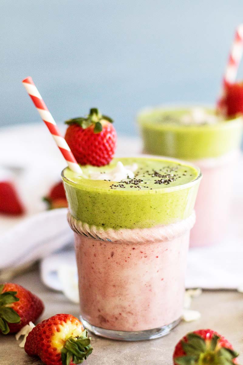 A close up of a pink and green strawberry colada smoothie.