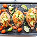 Sweet potatoes stuffed with beans and cheese and topped with avocado and salsa.