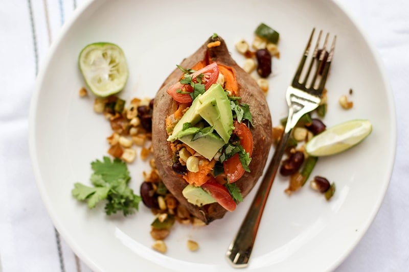 A Mexican stuffed sweet potato on a white plate.