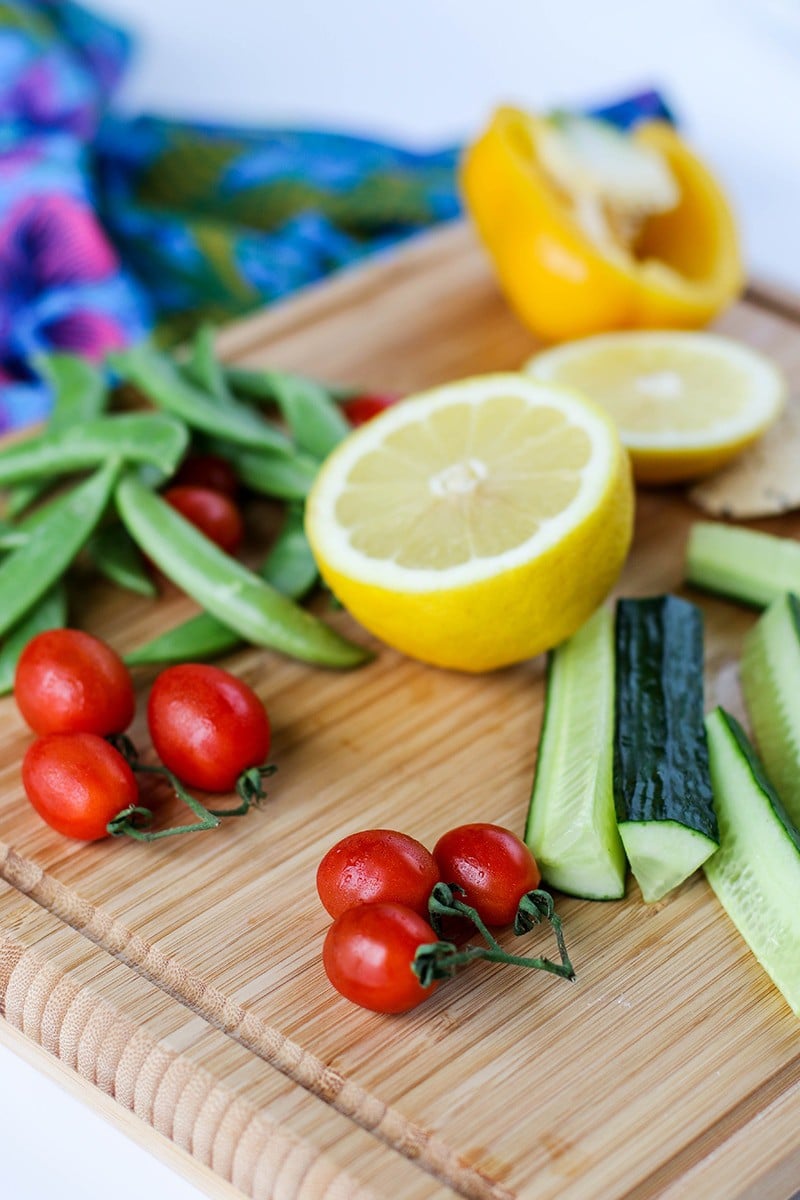 A cutting board with veggies prepared to dip.