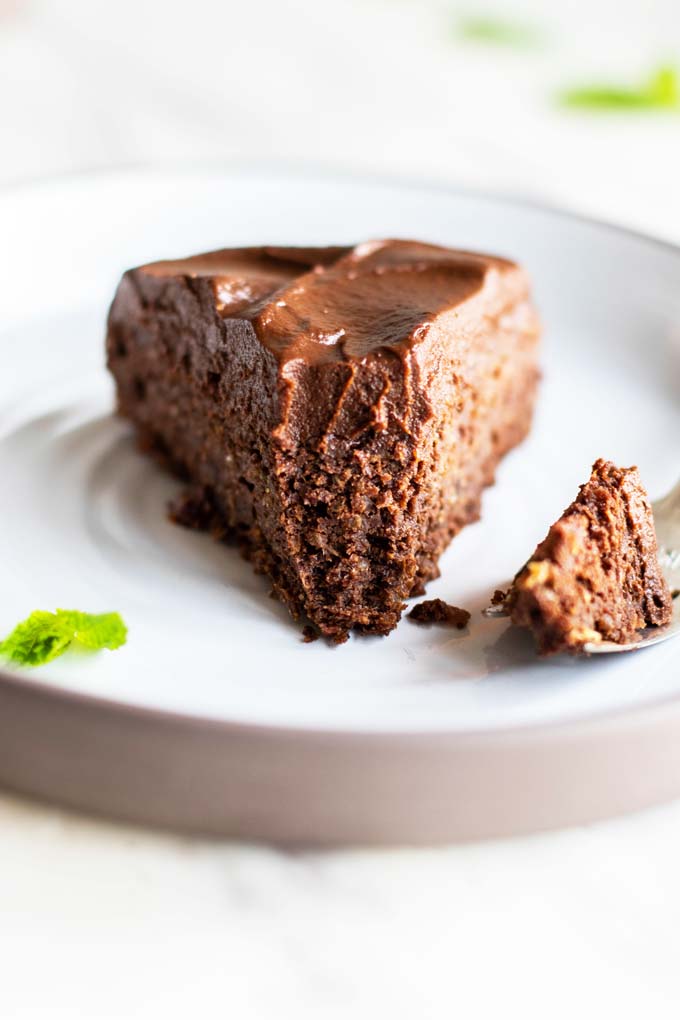 A slice of cake with a bite taken out of the end to show the fudgy texture.