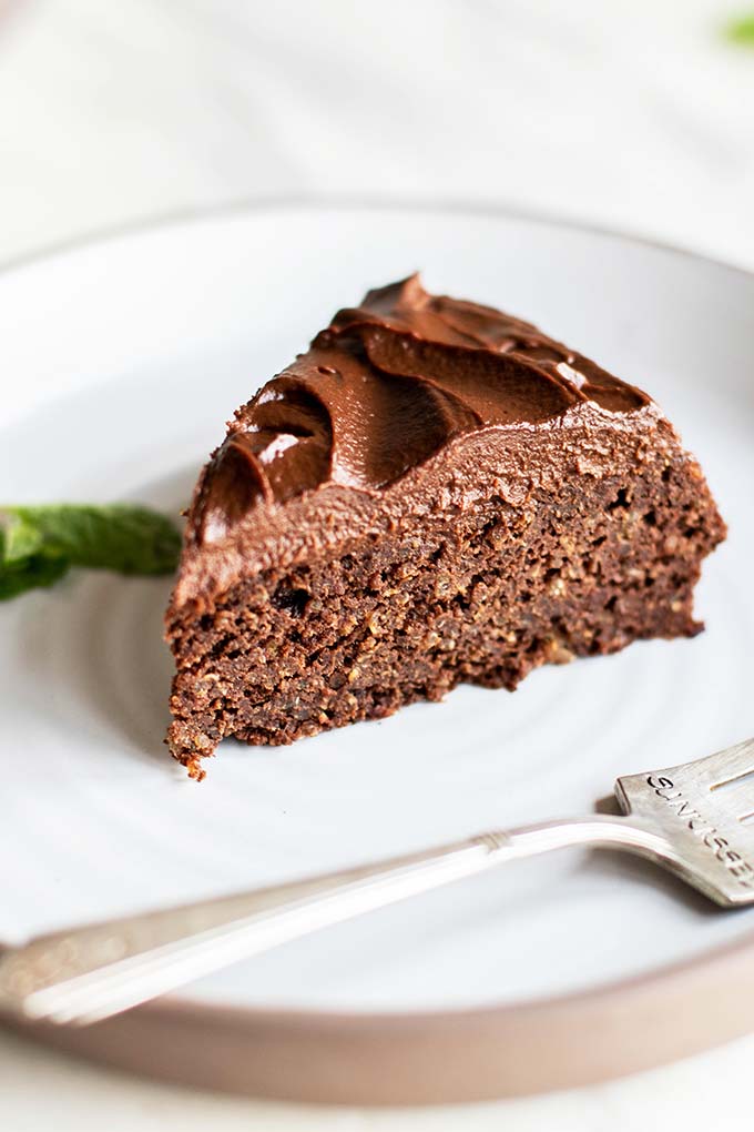 A slice of chocolate quinoa cake with a thick layer of sweet potato frosting.