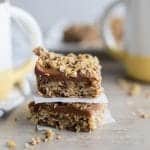 Gluten Free Date Bars stacked up next to a cup of tea.