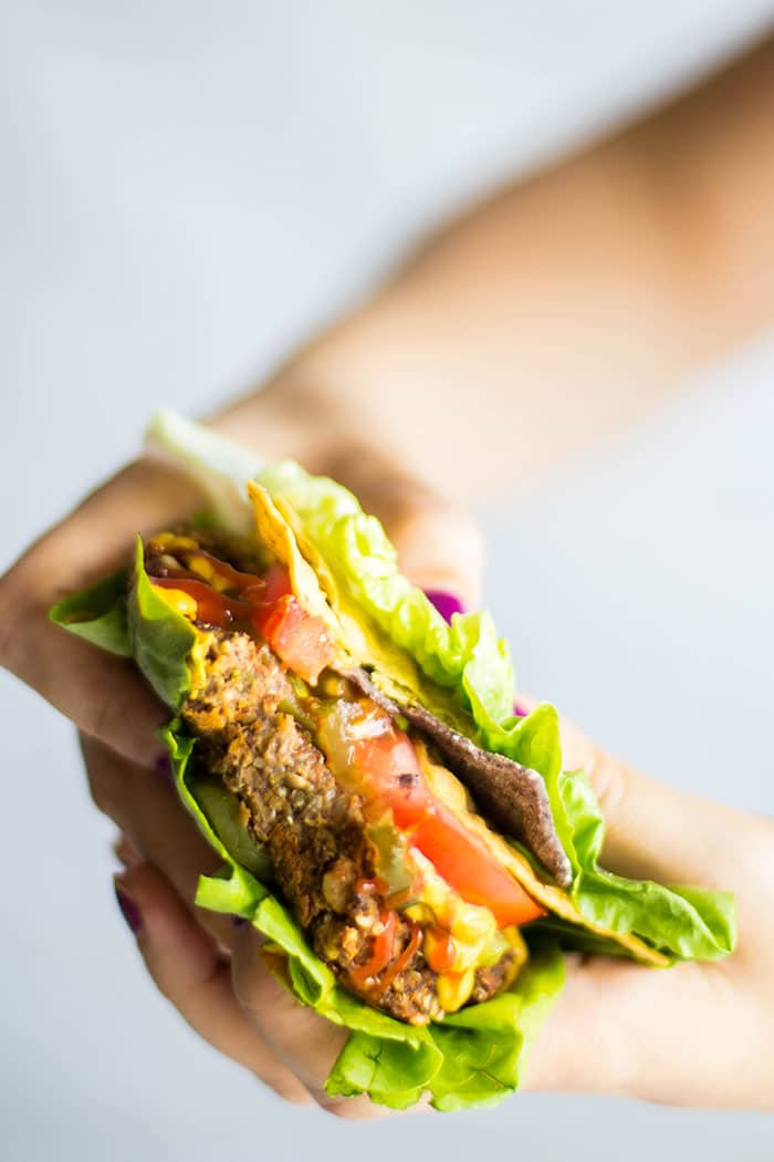 A pumpkin seed veggie burger with a bite taken out of it.