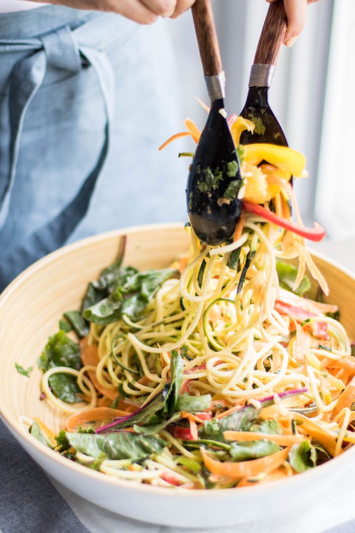 Michelle tossing the Asian Orange Zoodle Salad with a healthy tahini dressing.