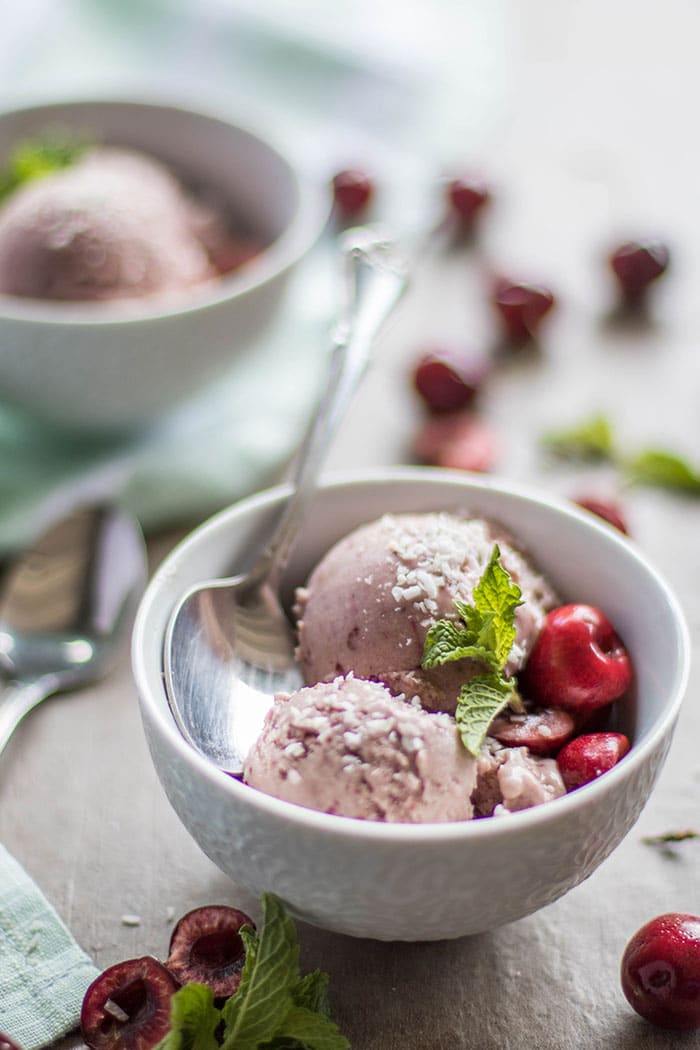 A side view of two bowls of vegan cherry coconut sorbet.