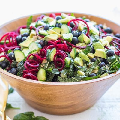 A bowl filled with a colorful blueberry kale salad.