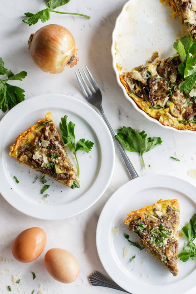 Two plates with slices of sweet potato frittata sprinkled with parsley.