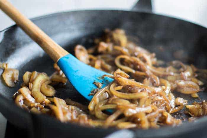 A skillet with caramelized onions, showing the dark and smooth texture once they are finished.