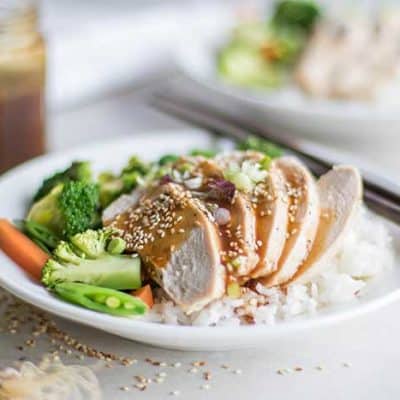 A plate of easy soy free teriyaki sauce drizzled on a plate of chicken and rice.