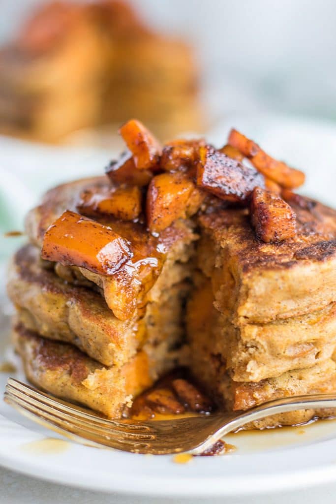 A stack of butternut squash pancakes with a bite taken out of them.