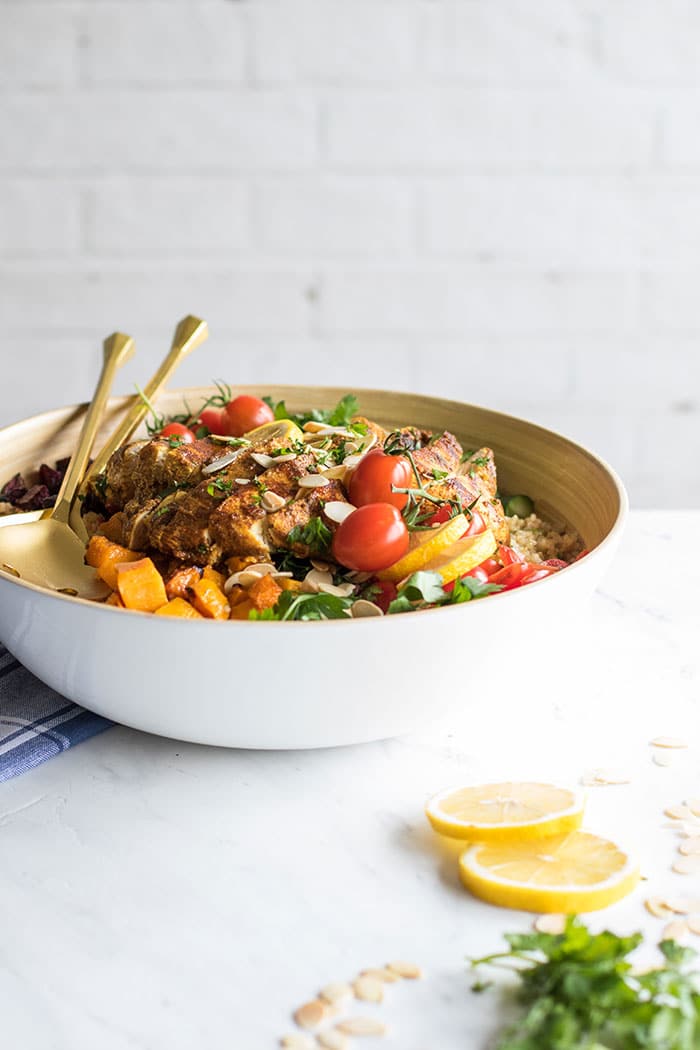 A bowl on a table filled with a Moroccan Chicken Quinoa Salad.