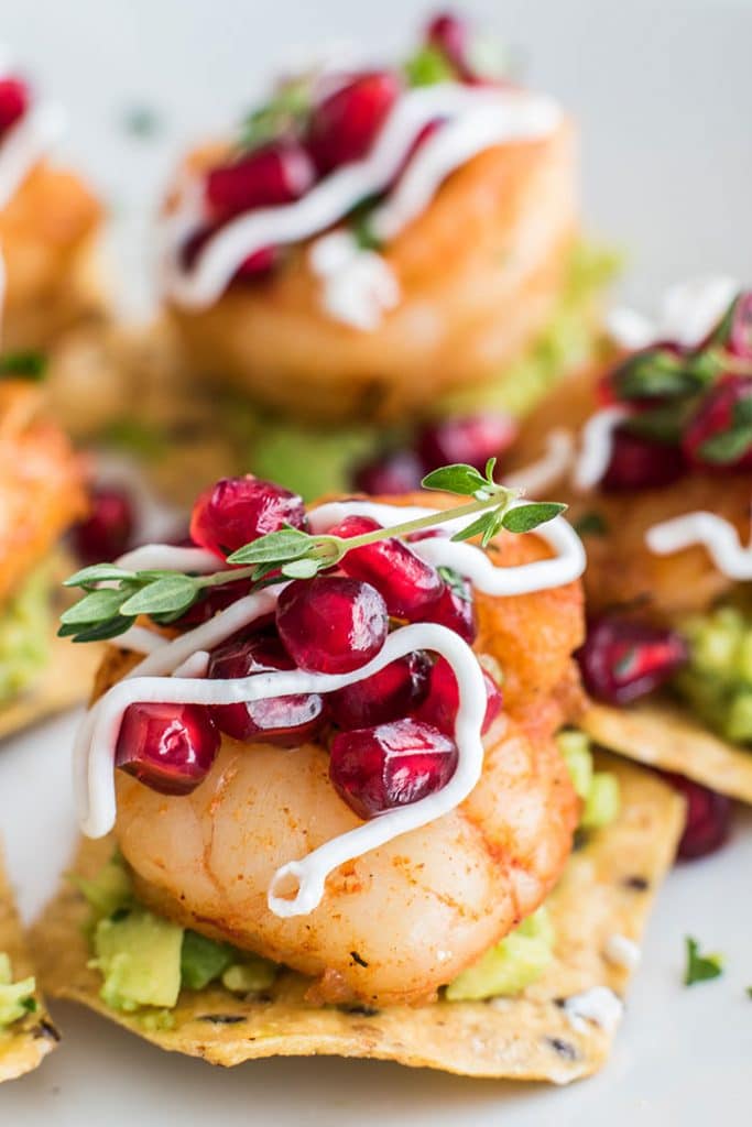 Mini Shrimp Tostadas with Pomegranate Guacamole / The perfect healthy party appetizer! Blackened shrimp, guacamole, and a tangy pomegranate salsa.