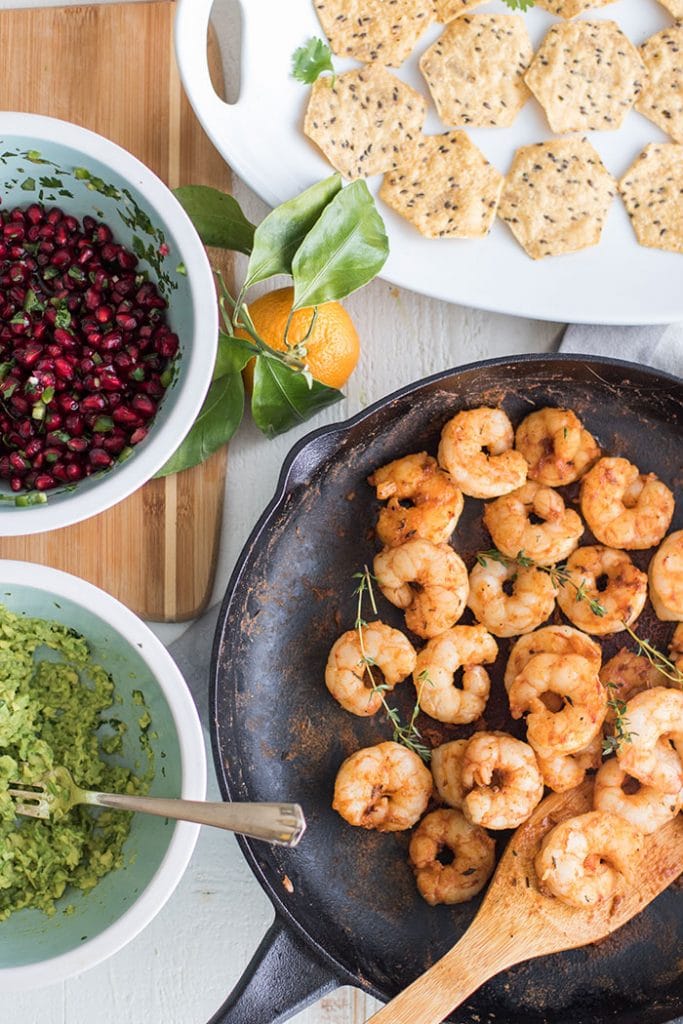 Mini Shrimp Tostadas with Pomegranate Guacamole / The perfect healthy party appetizer! Blackened shrimp, guacamole, and a tangy pomegranate salsa.