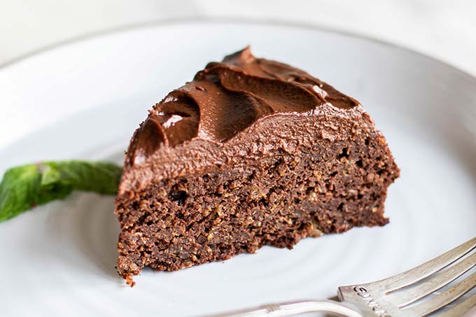 A piece of chocolate cake with a thick layer of healthy chocolate frosting.