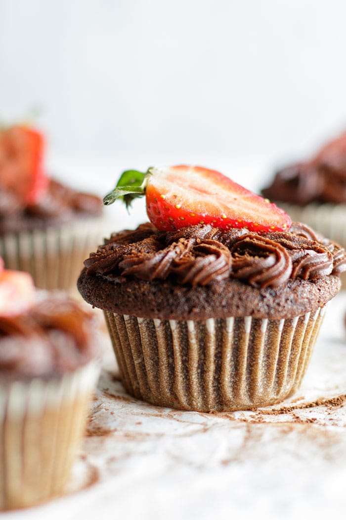 A healthy chocolate cupcake with a strawberry.