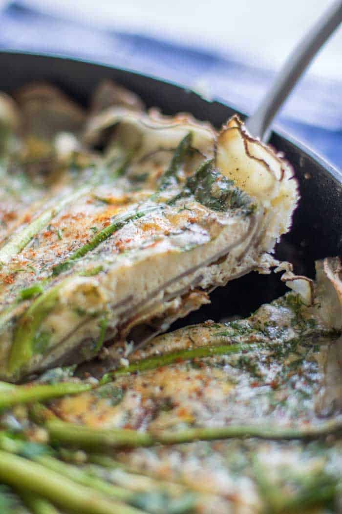 A slice of frittata with a potato crust being lifted out of the pan.