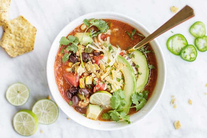 A bowl of soup filled with lots of toppings.