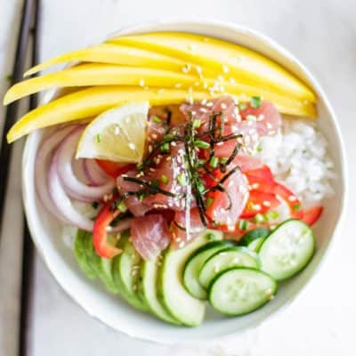 A poke bowl with ahi tuna, avocado, onion, mango and cucumbers.