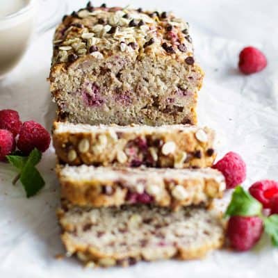 A loaf of gluten free banana raspberry bread studded with dark chocolate chips.