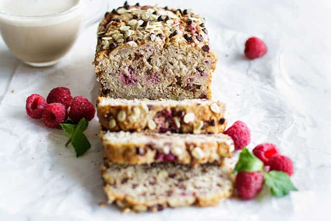 A loaf of healthy banana raspberry bread cut into thick slices.