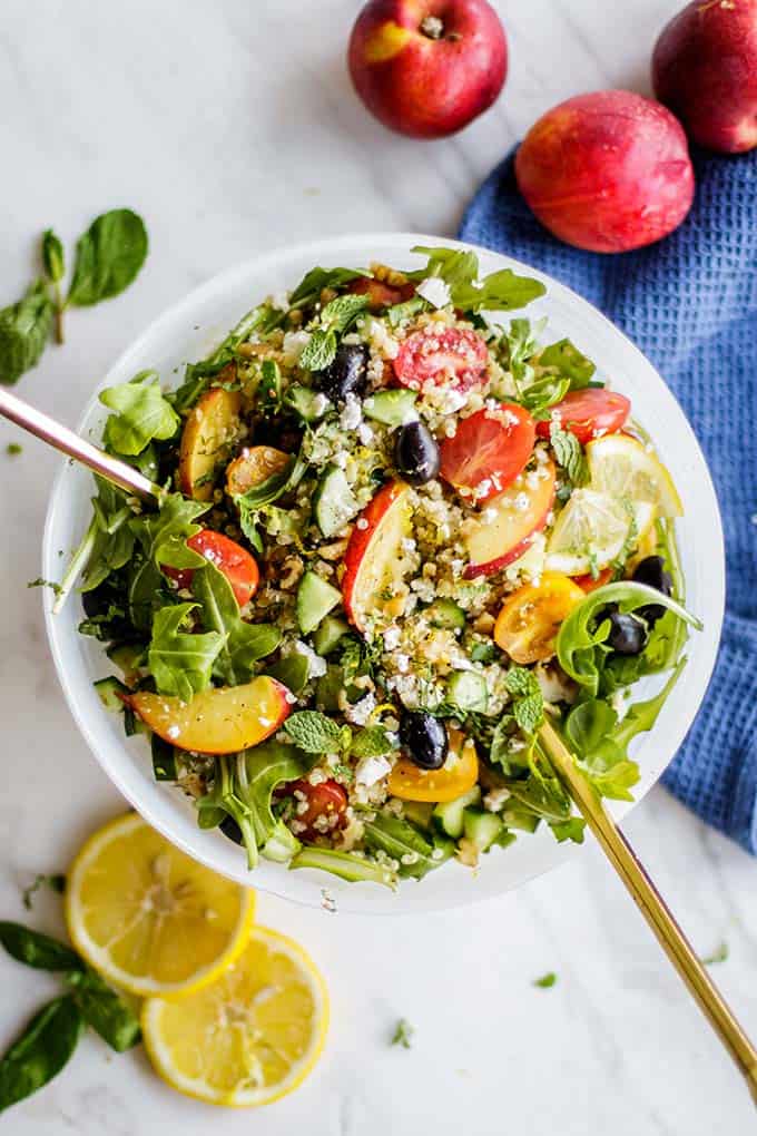 To view of a greek quinoa salad packed with arugula, nectarines, mint and basil.