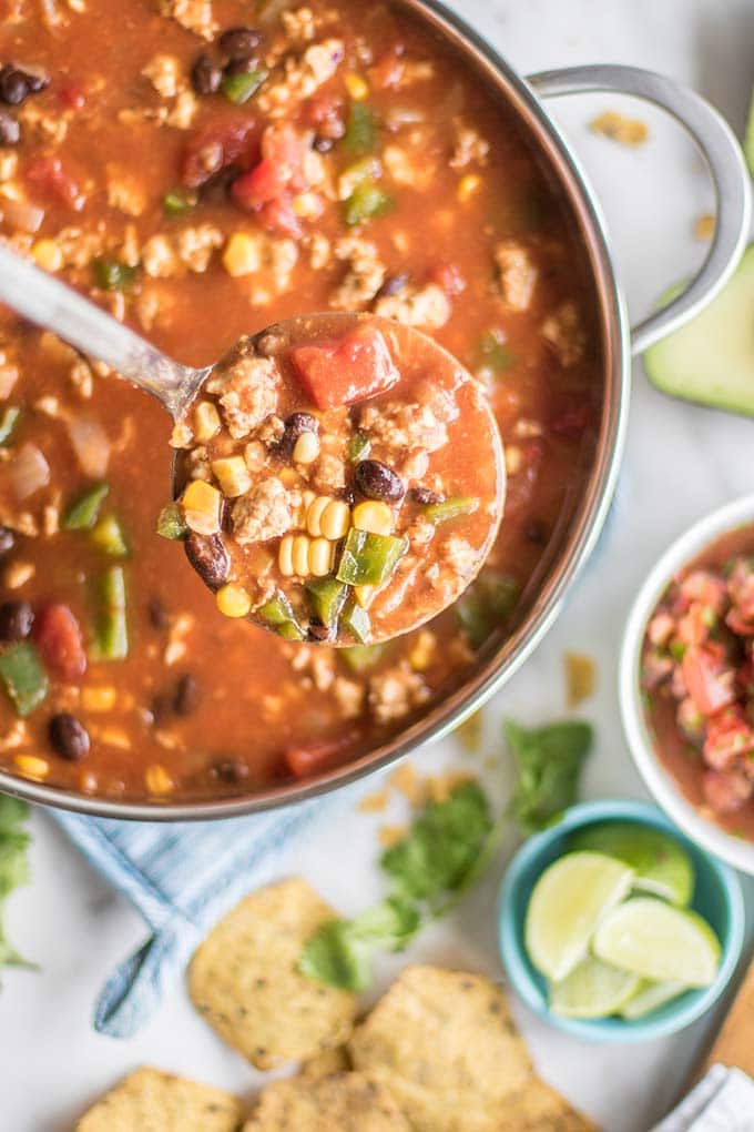 A pot of taco soup with a ladle taking some out.