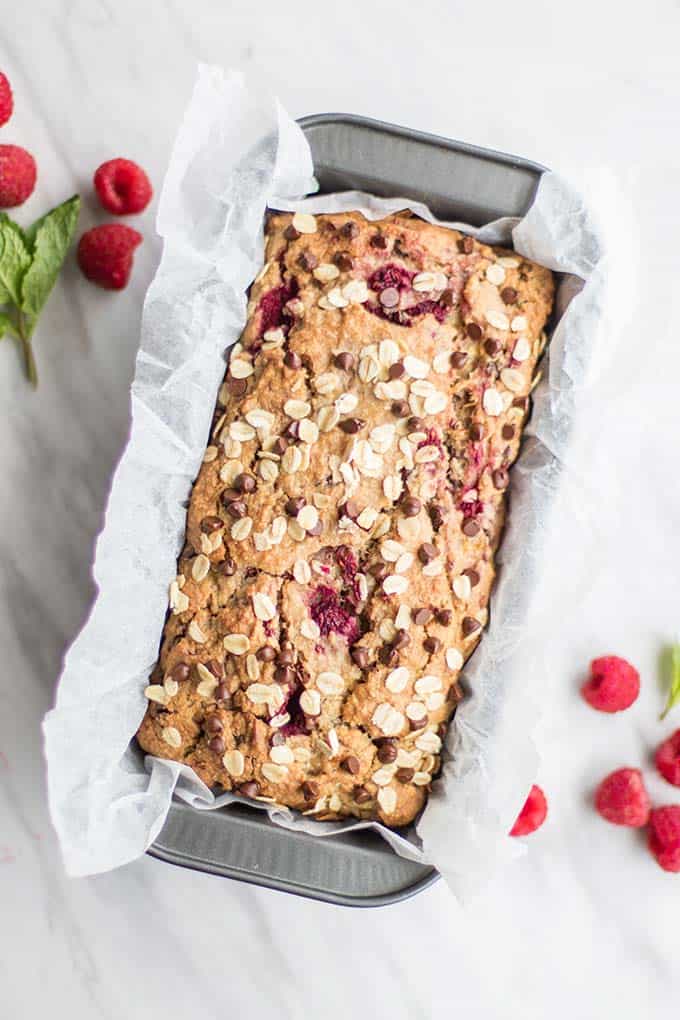 A baked loaf of banana raspberry bread still in the pan.