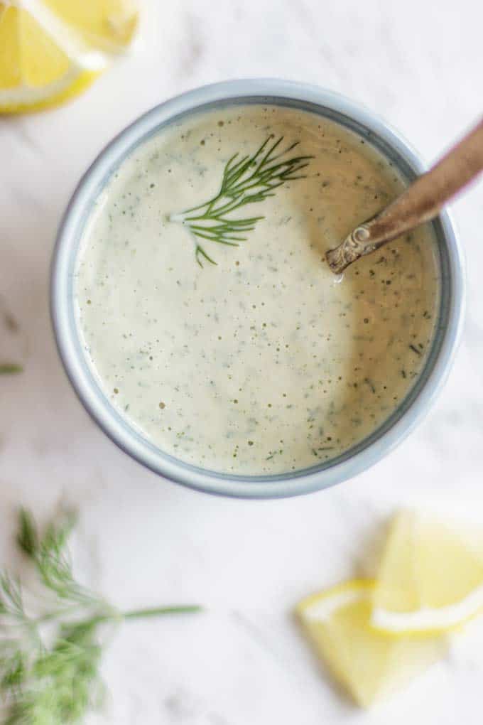 A bowl with a zippy creamy dill tahini salad dressing.