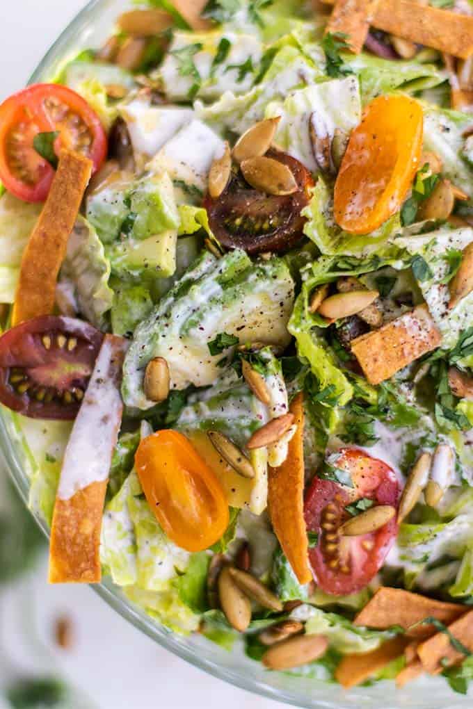 A close-up view of creamy vegan caesar dressing drizzled on this Mexican inspired salad.