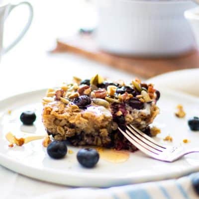 A plate with banana baked oatmeal in front of a cup of coffee.