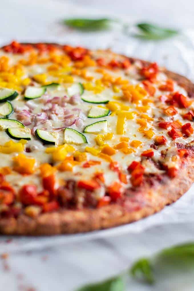 A view of half of a large pizza topped with colorful vegetables.
