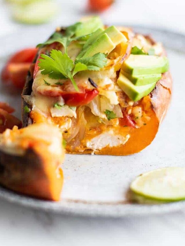 A twice baked sweet potato cut open to show chicken and veggies inside.