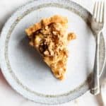 A healthy apple pie with a gluten free pie crust shown sliced on a plate.