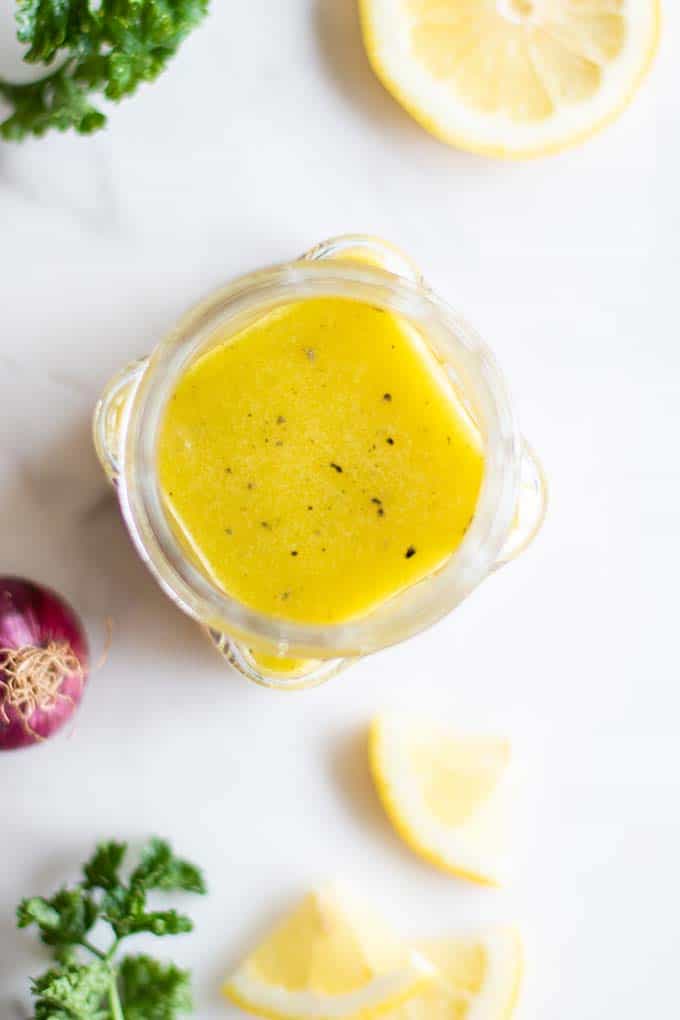 A bright yellow lemon vinaigrette in a jar.