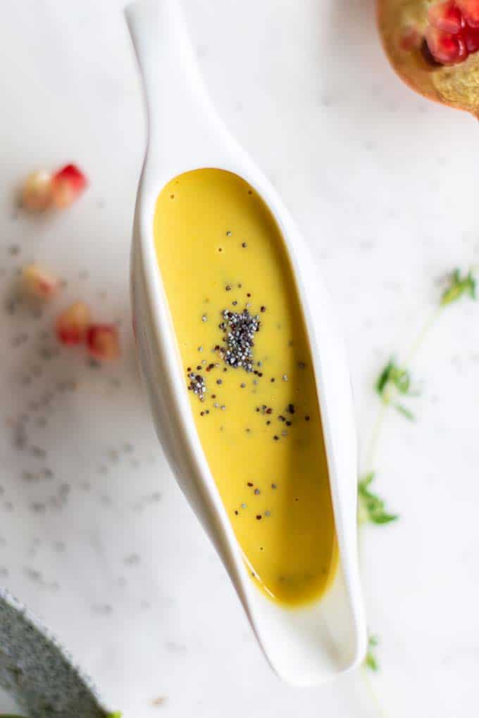 A close up of honey mustard salad dressing with poppyseeds.