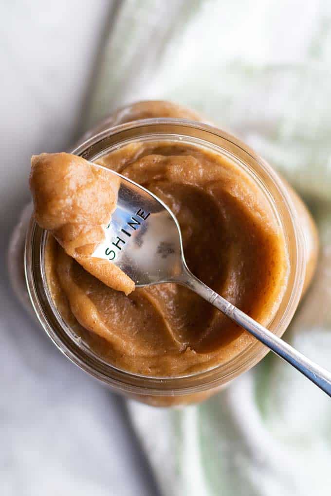 A spoon of date paste siting on a jar.