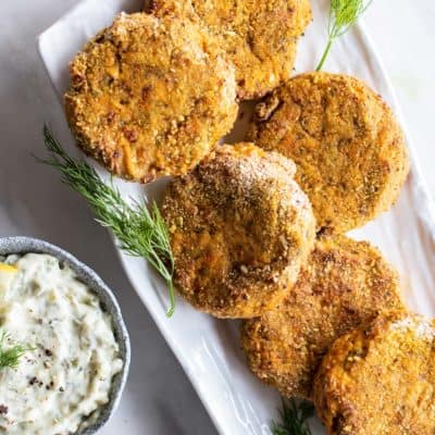 A platter with sweet potato salmon croquettes, showed with a tartar dipping sauce.