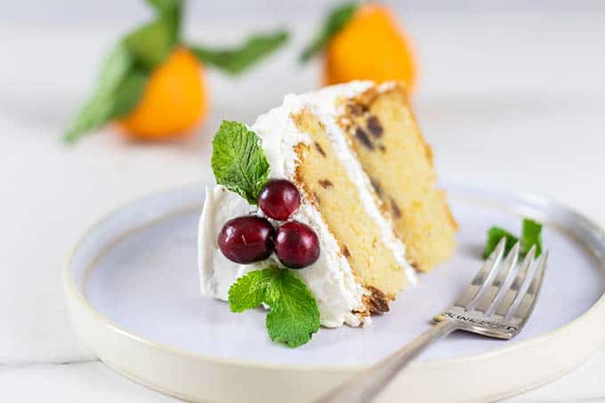 A slice of almond flour cake decorated with cranberries and mint.