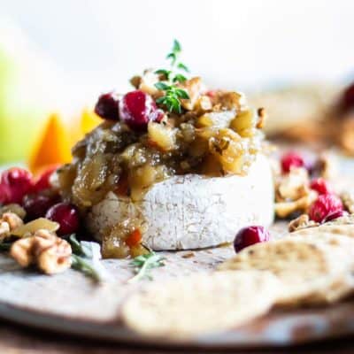 Baked Brie with pear chutney on a cheese board.